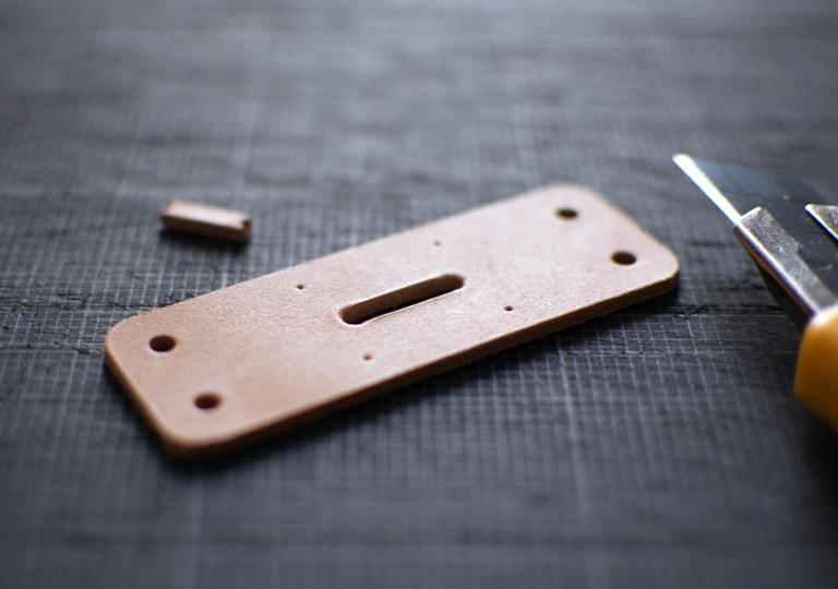 裁断した後の革とカッターナイフ