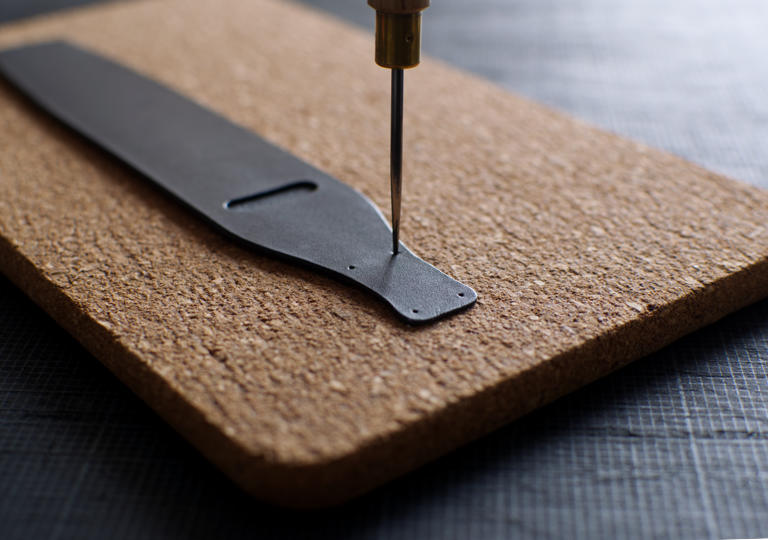 丸ギリを挿して革に点穴を写すところ