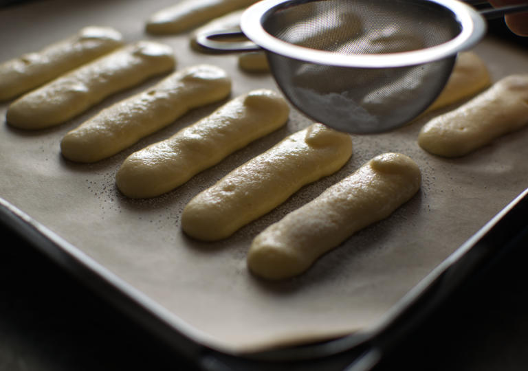 生地の上に粉糖をふるっている